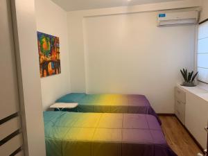 1 dormitorio con 1 cama con colcha de arco iris en Mirador Salta I Vistas panorámicas, en Salta