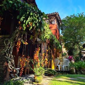 une maison avec un bouquet de fleurs dans la cour dans l'établissement Pousada Cachoeira, à Abraão