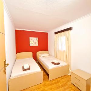 two beds in a small room with red walls at Villa Nikolas in Gavalochori