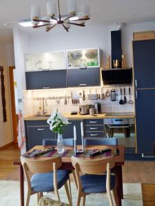 eine Küche mit einem Holztisch und blauen Schränken in der Unterkunft "Balmgarten" im Naturpark Usedom, Bio Solarhaus mit großem Garten in Balm