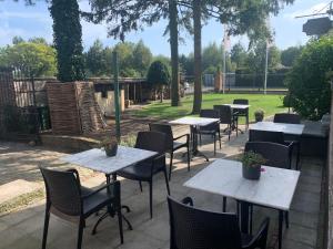 une rangée de tables et de chaises dans un parc dans l'établissement Hotel Vredehof, à Damme