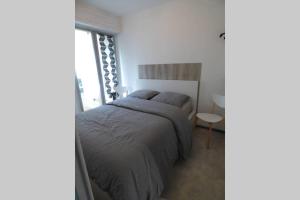sypialnia z łóżkiem i oknem w obiekcie Appartement entier en résidence, fonctionnel et confortable w mieście Cabourg