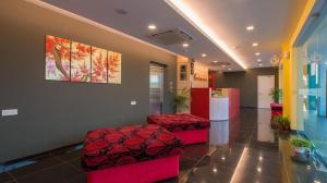 a lobby with two red stools and a painting on the wall at Riverfront Boutique Hotel in Melaka