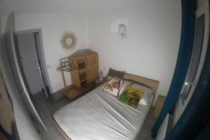 ein kleines Schlafzimmer mit einem Bett und einem Spiegel in der Unterkunft T3 PIEDS DANS L'EAU CLIM WIFI TERRASSE VUE MER in Banyuls-sur-Mer