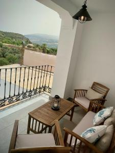 balcón con mesa, sillas y vistas en La Casa del Puente, en Lecrin