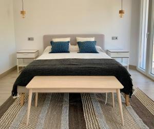 1 dormitorio con 1 cama grande con almohadas azules en La Casa del Puente, en Lecrin
