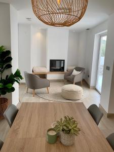 ein Wohnzimmer mit Tisch und Stühlen und einem Fernseher in der Unterkunft La Casa del Puente in Lecrin