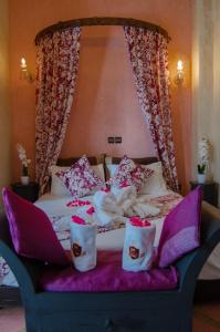 un letto a baldacchino con rose rosse di Riad L'Orchidée Suites & Spa a Marrakech