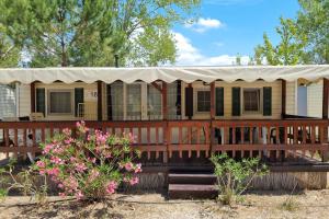 una casa con porche con toldo blanco en Chalet 4 or 6 persons Toscana Viareggio Camping Bosco Verde Italië, en Torre del Lago Puccini