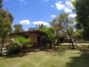a small house with a hammock in a yard at Cabaña Pelulandia in Playa Verde