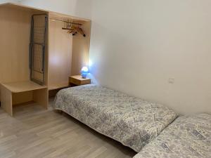 een slaapkamer met twee bedden en een tafel met een lamp bij Studio Tabagnoz in Prémanon