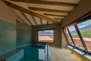 a swimming pool in a house with a window at Villa del Cielo in Tilcara