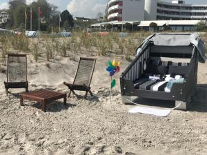 a bed on the beach with two chairs and a bench at Klarsinnchen 2 NEU !!! in Grömitz