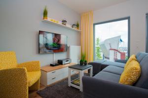 a living room with a couch and a tv at Ostsee - Maisonette - Appartement Nr 53 "Schöne Aussicht" im Strand Resort in Heiligenhafen