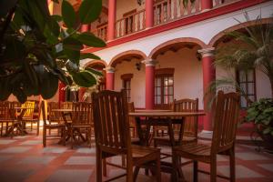an empty restaurant with wooden tables and chairs at Hotel Monasterio in Sucre