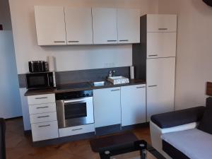 een keuken met witte kasten en een fornuis met oven bij Apartment Laudon in Wenen