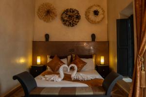 una camera da letto con un letto con due cigni sopra di Riad L'Orchidée Suites & Spa a Marrakech