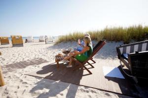 a woman sitting in a chair on the beach at Klarsinnchen 4 NEU !!! in Grömitz