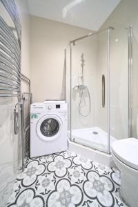 a bathroom with a washing machine and a shower at Super Cozy Apartment for Two, Vilnius City Centre in Vilnius