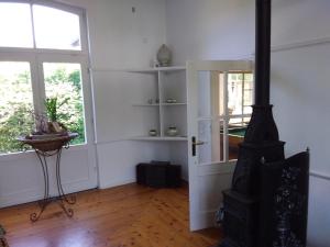 a living room with a stove and two windows at Ferienbahnhof Utzerath in Utzerath