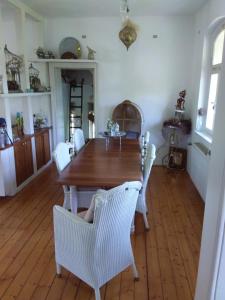 a dining room with a wooden table and white chairs at Ferienbahnhof Utzerath in Utzerath