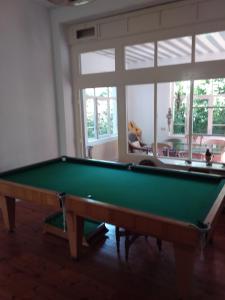 een groene pooltafel in een kamer met een raam bij Ferienbahnhof Utzerath in Utzerath