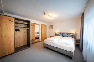 een slaapkamer met een bed en een bureau en een bed sidx sidx sidx bij Hotel Monte44 in Selva di Val Gardena