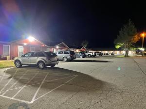 - un parking avec des voitures garées la nuit dans l'établissement PINE VALLEY MOTEL, à Spruce Pine