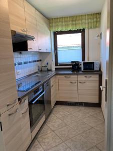 a kitchen with stainless steel appliances and a window at Ferienwohnung Im Moos in Oberstaufen