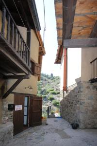 an alley between two buildings with a mountain in the background at River House in Kakopetria