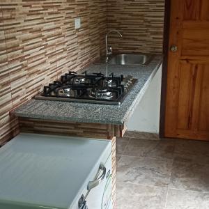a kitchen with a stove and a sink at La Casa de Thurys in Pedasí Town