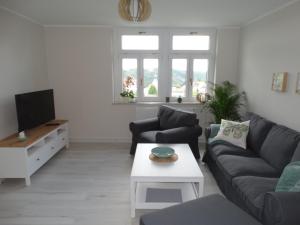 a living room with a couch and a tv at Ferienwohnung Sonnenblick in Hohnstein