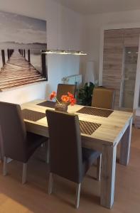 comedor con mesa de madera y sillas en Laboe-Appartement im Kapitänshaus, en Laboe