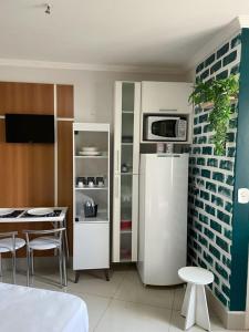 a kitchen with a white refrigerator and a table with chairs at CTC Araras in Caldas Novas