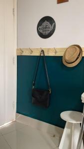 Un sombrero y un bolso colgados en una pared azul. en CTC Araras, en Caldas Novas