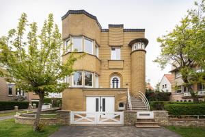 a brick house with a white gate in front of it at Villa My Corner in De Panne