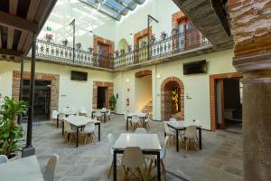 a restaurant with tables and chairs and a balcony at Hotel Boutique Casona de Santa Clara in Puebla