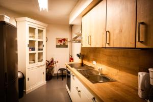 a kitchen with a sink and wooden cabinets at Ruime, gezellige vakantiewoning nabij Winterberg voor 2 tot 6 rustige natuurliefhebbers in Schmallenberg