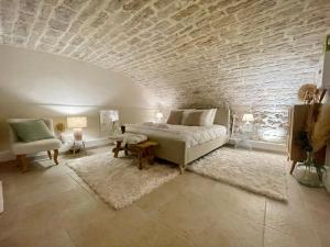 een slaapkamer met een bed en een bakstenen muur bij La Maison Pinot Noir in Gevrey-Chambertin