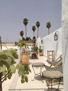 un patio con sedie, tavoli e palme di Riad Darsahalia a Marrakech