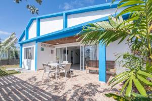 a blue and white house with a table and chairs at Casa Korora in San Andrés