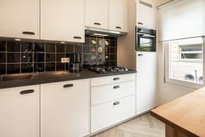 a kitchen with white cabinets and a counter top at Villa My Corner in De Panne +6 photos