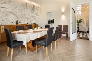 a dining room with a white table and chairs at Villa My Corner in De Panne