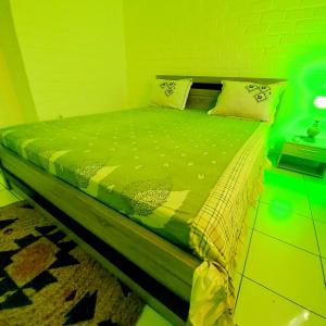 1 cama con edredón verde y almohadas en LÃCAZÈRĂ Sãfãrì, en Mamoudzou