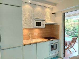 a kitchen with a sink and a microwave at Plage la Salis 3 chambres, Jardin - 3 bedrooms in Antibes