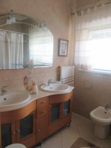 a bathroom with two sinks and a toilet at MARIA INÊS HOUSE in Nazaré
