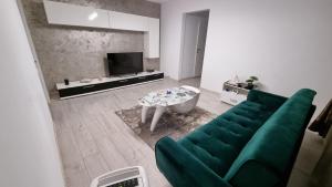 a living room with a green couch and a table at Stone Bridge Apartment in Iaşi