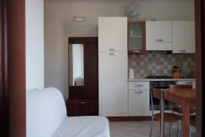 eine Küche mit weißen Schränken und einem Tisch im Zimmer in der Unterkunft La Cittadella Porto Potenza Picena(MC) in Porto Potenza Picena