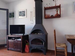 ein Kamin in einem Wohnzimmer mit Fernseher in der Unterkunft Casa Kenya: Dúplex con azotea y magníficas vistas. in Rodalquilar