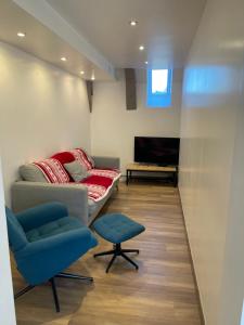 un salon avec un canapé et deux chaises dans l'établissement LE DOMAINE DE LA LOUVE BLANCHE, à Le Mont-Dore